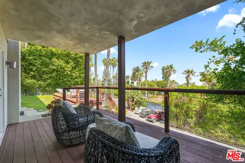 a view of a patio with table and chairs with wooden floor and fence