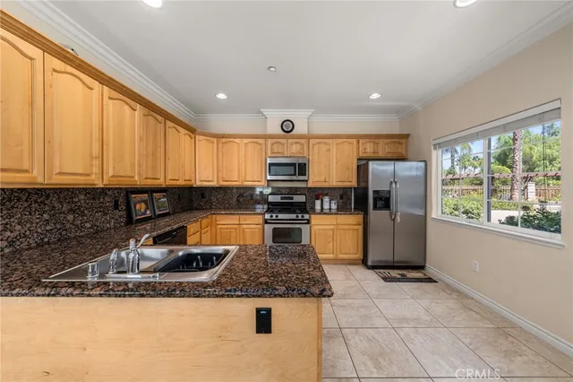 a kitchen with stainless steel appliances granite countertop a sink a stove and a refrigerator