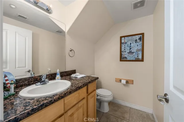 a bathroom with a granite countertop sink toilet and a mirror