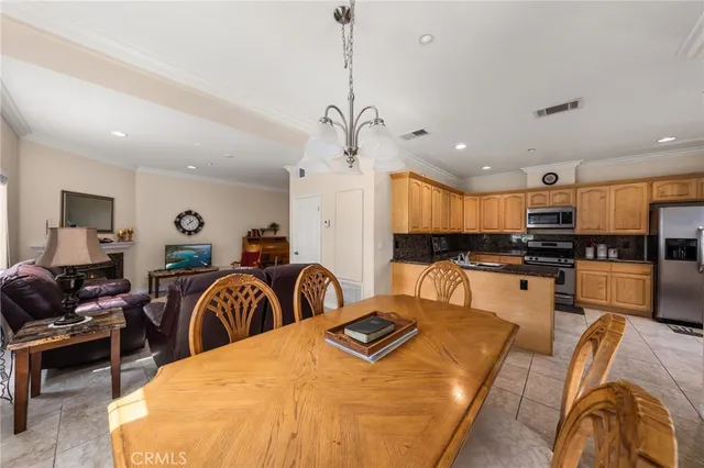 a living room with furniture a kitchen view and a chandelier