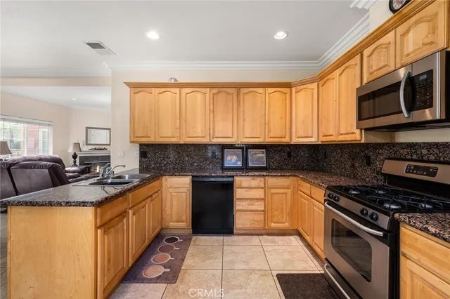 a kitchen with stainless steel appliances granite countertop a stove a sink and a microwave