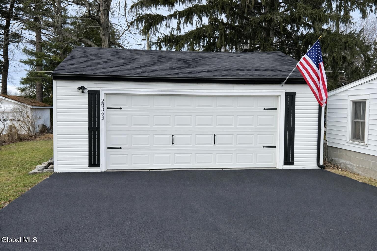28363 Lotts Grove Road Lyme, NY 13622 - Photo 8 of 35 American flag and white garage in woods