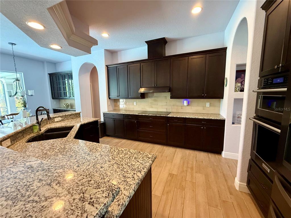 13110 Bamboo Street Spring Hill, FL 34609 - Photo 16 of 56 a large kitchen with a large counter top stainless steel appliances and cabinets