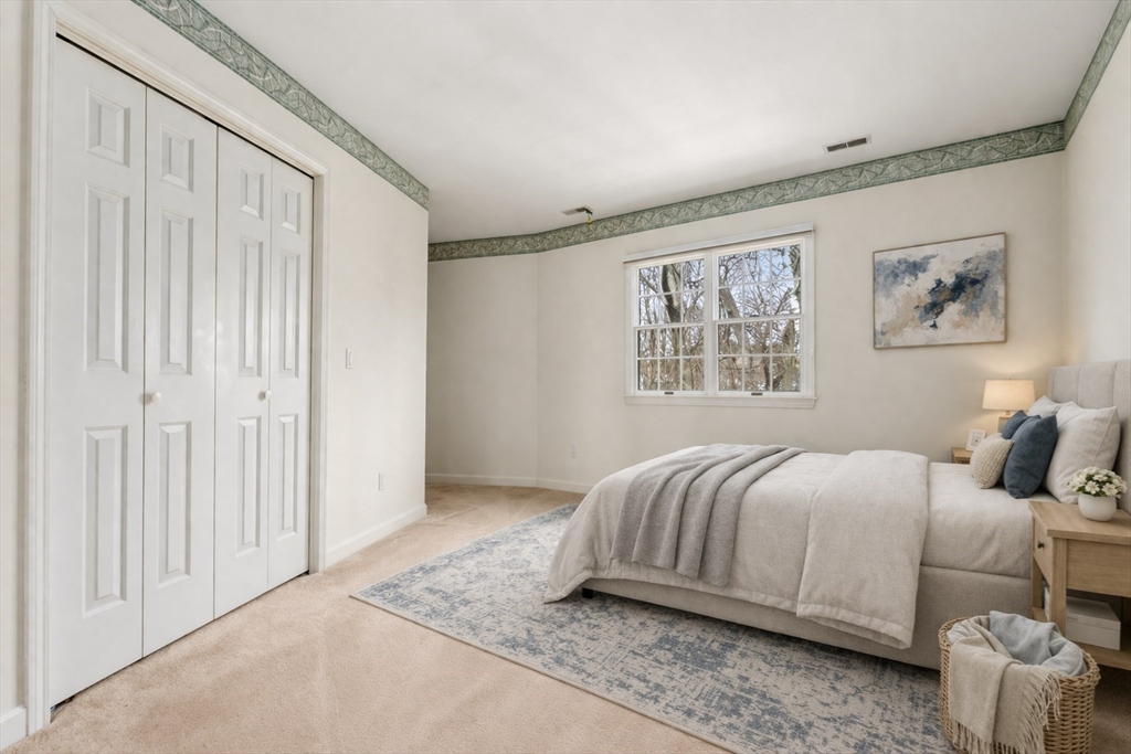 3 Parker Ridge Way, Unit 3 Newburyport, MA 01950 - Photo 19 of 40 a bedroom with a bed and a painting on the wall