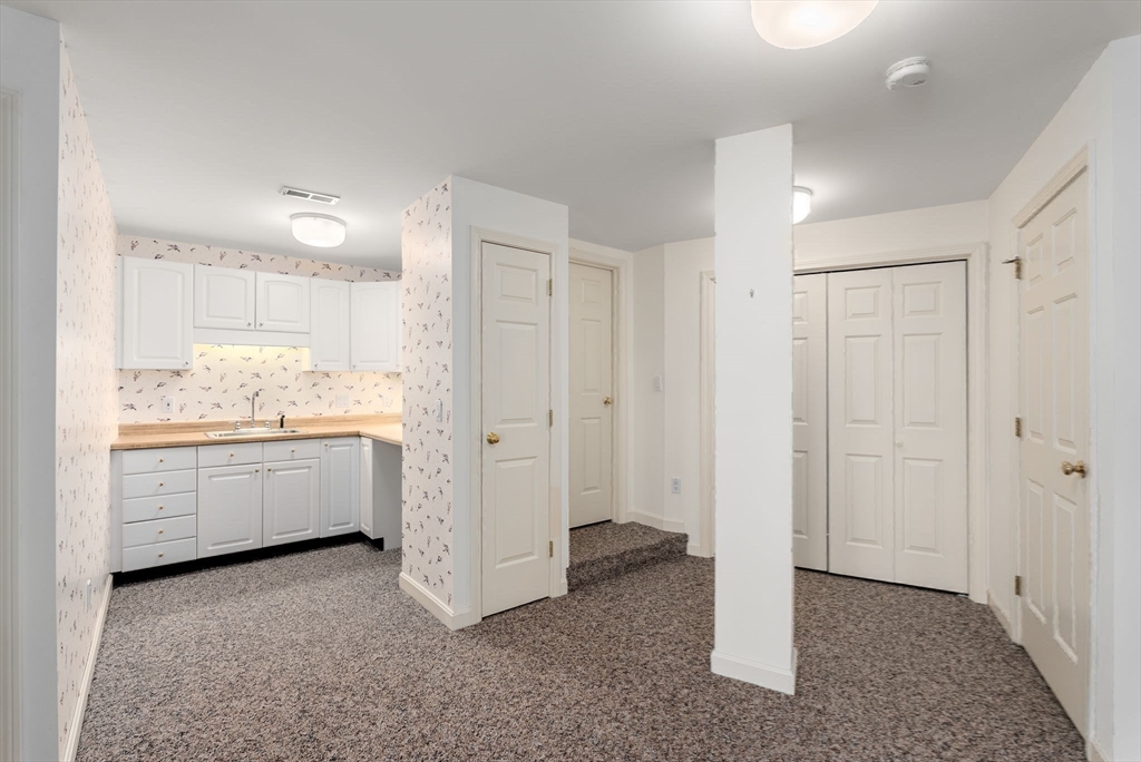 3 Parker Ridge Way, Unit 3 Newburyport, MA 01950 - Photo 29 of 40 a room with a white bed cabinets and a window