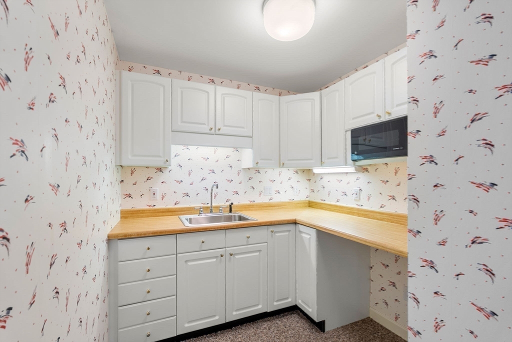 3 Parker Ridge Way, Unit 3 Newburyport, MA 01950 - Photo 30 of 40 a kitchen with granite countertop white cabinets and sink