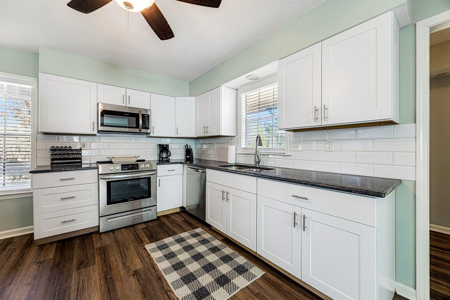 401 North Sanga Road Memphis, TN 38018 - Photo 11 of 27 Kitchen with white cabinetry, stainless steel appliances, dark stone countertops, dark wood-style floors, and a ceiling fan