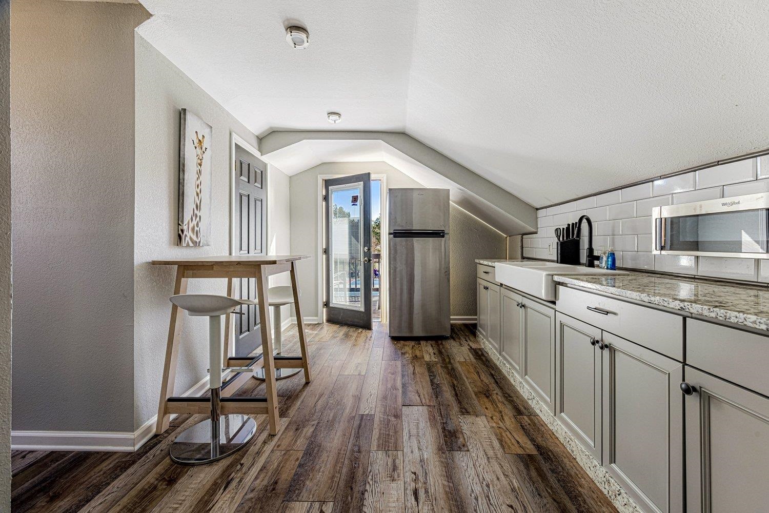 401 North Sanga Road Memphis, TN 38018 - Photo 18 of 27 Kitchen featuring dark wood finished floors, stainless steel appliances, light stone counters, a textured ceiling, and decorative backsplash