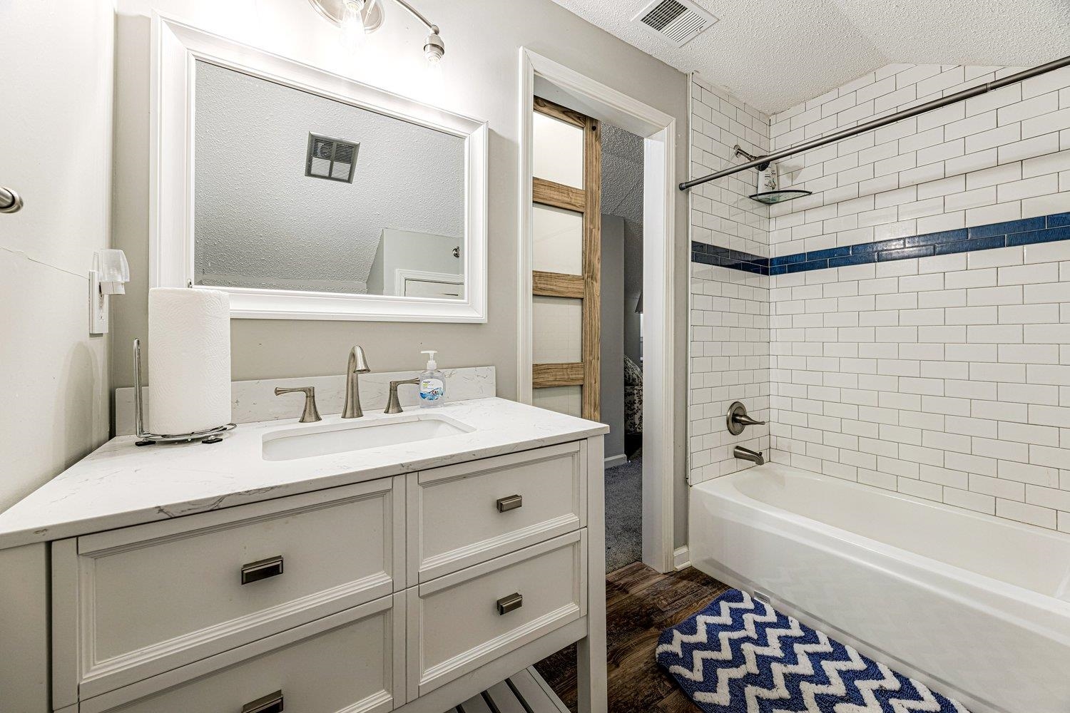 401 North Sanga Road Memphis, TN 38018 - Photo 19 of 27 Bathroom with vanity, shower / bath combination, dark wood-style floors, and a textured ceiling