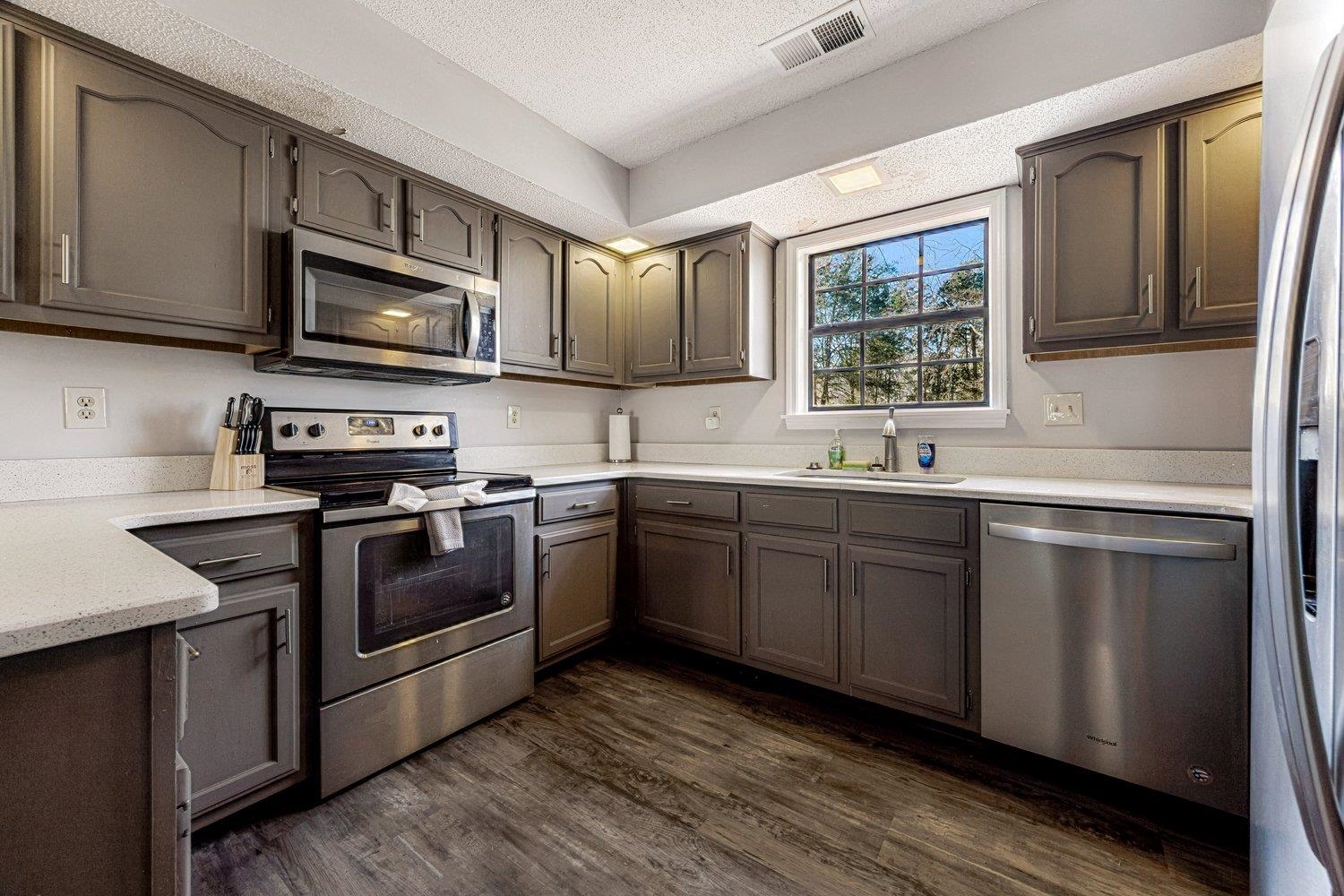 401 North Sanga Road Memphis, TN 38018 - Photo 23 of 27 Kitchen featuring stainless steel appliances, a textured ceiling, and dark wood-type flooring
