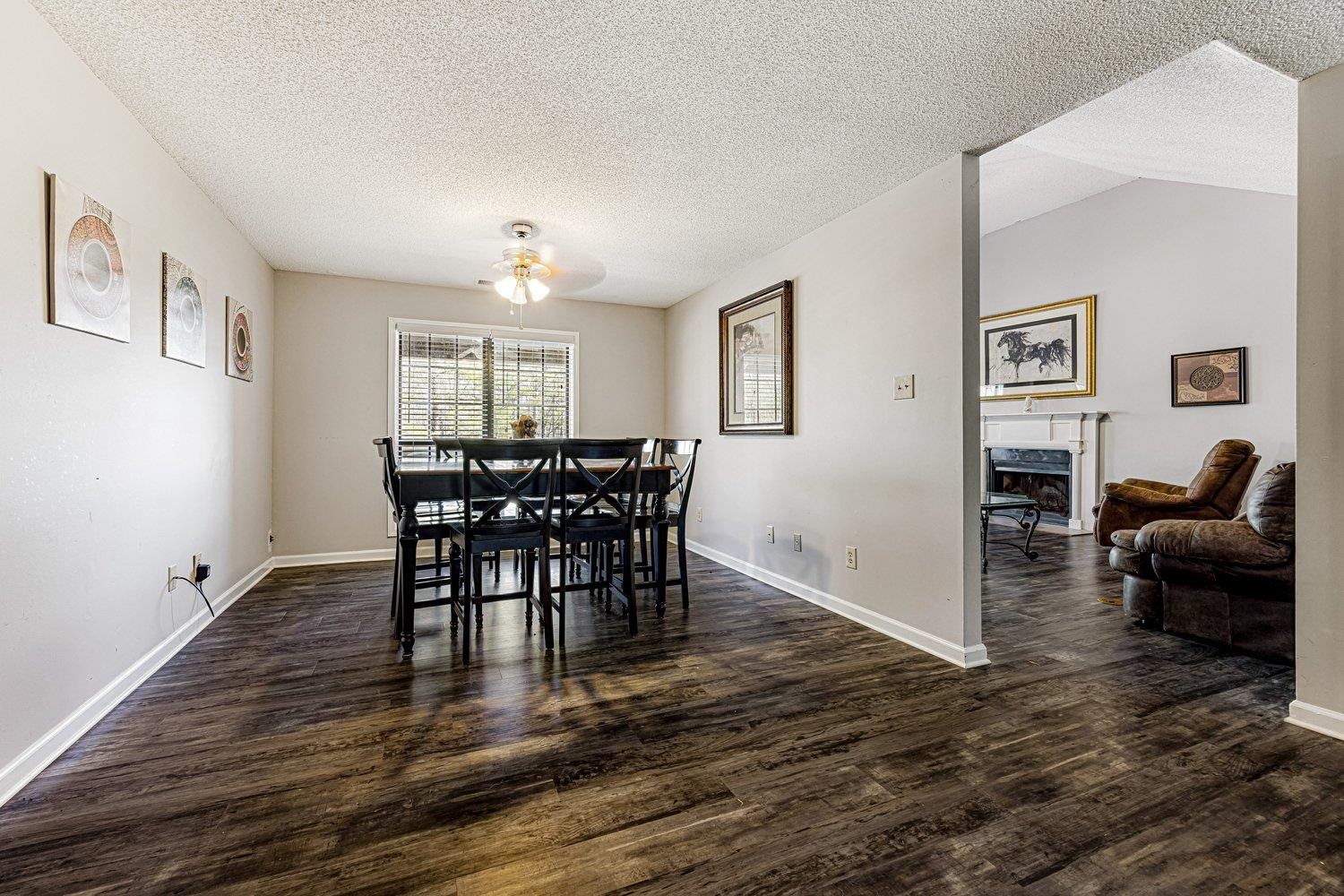 401 North Sanga Road Memphis, TN 38018 - Photo 24 of 27 Dining area with a textured ceiling, a fireplace, dark wood-style flooring, and a ceiling fan