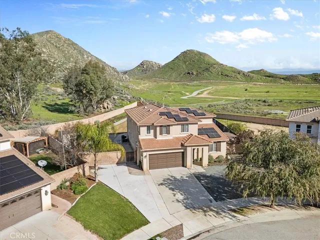a front view of a house with a yard and mountain view in back
