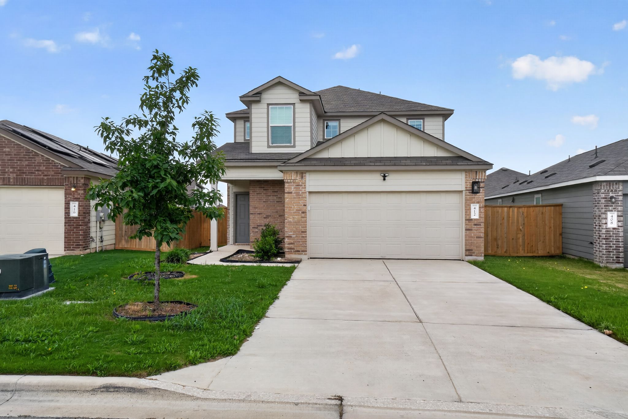 412 Perfect World Loop Jarrell, TX 76537 - Photo 1 of 15 Two-story residence featuring a brick and siding facade, a two-car garage, and a concrete driveway