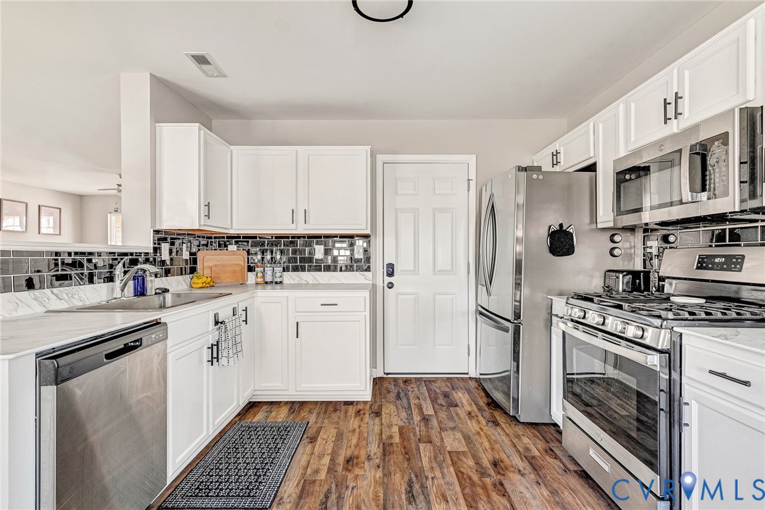 2702 Amherst Ridge Loop Colonial Heights, VA 23834 - Photo 14 of 38 a kitchen with granite countertop a stove top oven sink and cabinets