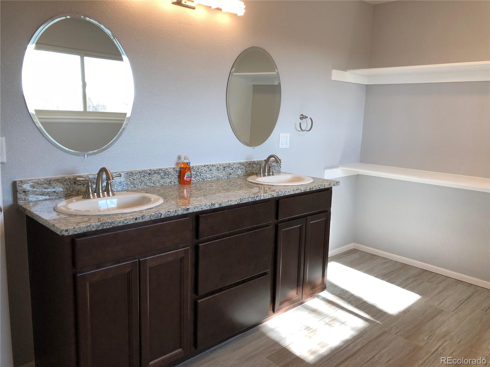 39592 County Road 18 Roggen, CO 80652 - Photo 15 of 34 a bathroom with a double vanity sink and a mirror