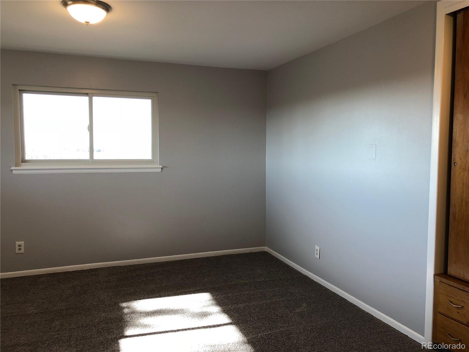 39592 County Road 18 Roggen, CO 80652 - Photo 18 of 34 an empty room with wooden floor and windows