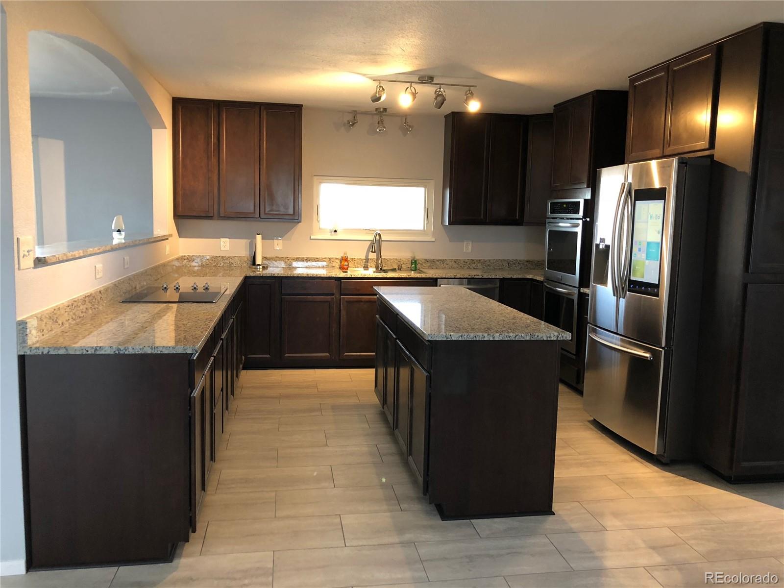 39592 County Road 18 Roggen, CO 80652 - Photo 4 of 34 a kitchen with kitchen island granite countertop a sink counter top space cabinets and stainless steel appliances