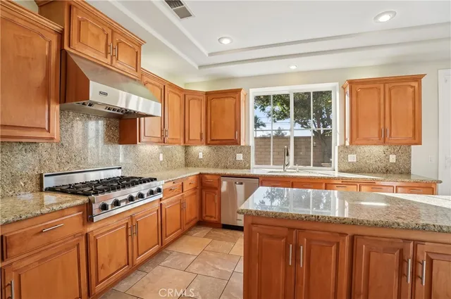 a kitchen with stainless steel appliances granite countertop a stove sink and cabinets