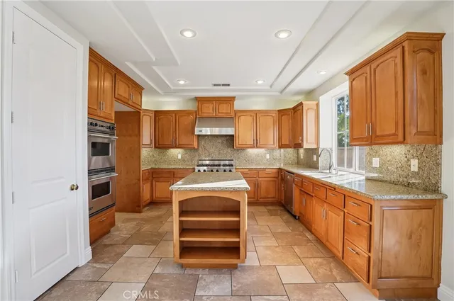 a kitchen with cabinets and stainless steel appliances