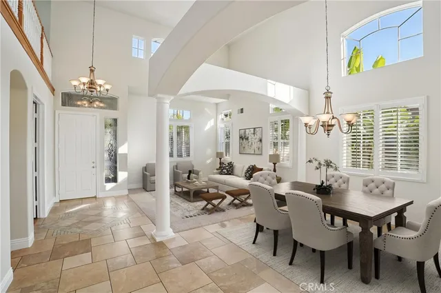 a view of a livingroom with a chandelier fan and windows