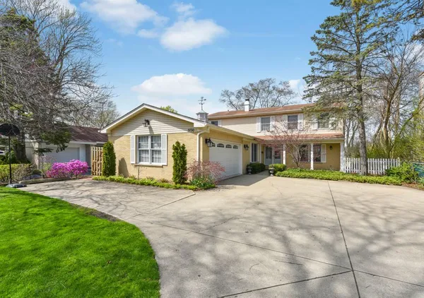 a view of a house with a yard and large trees