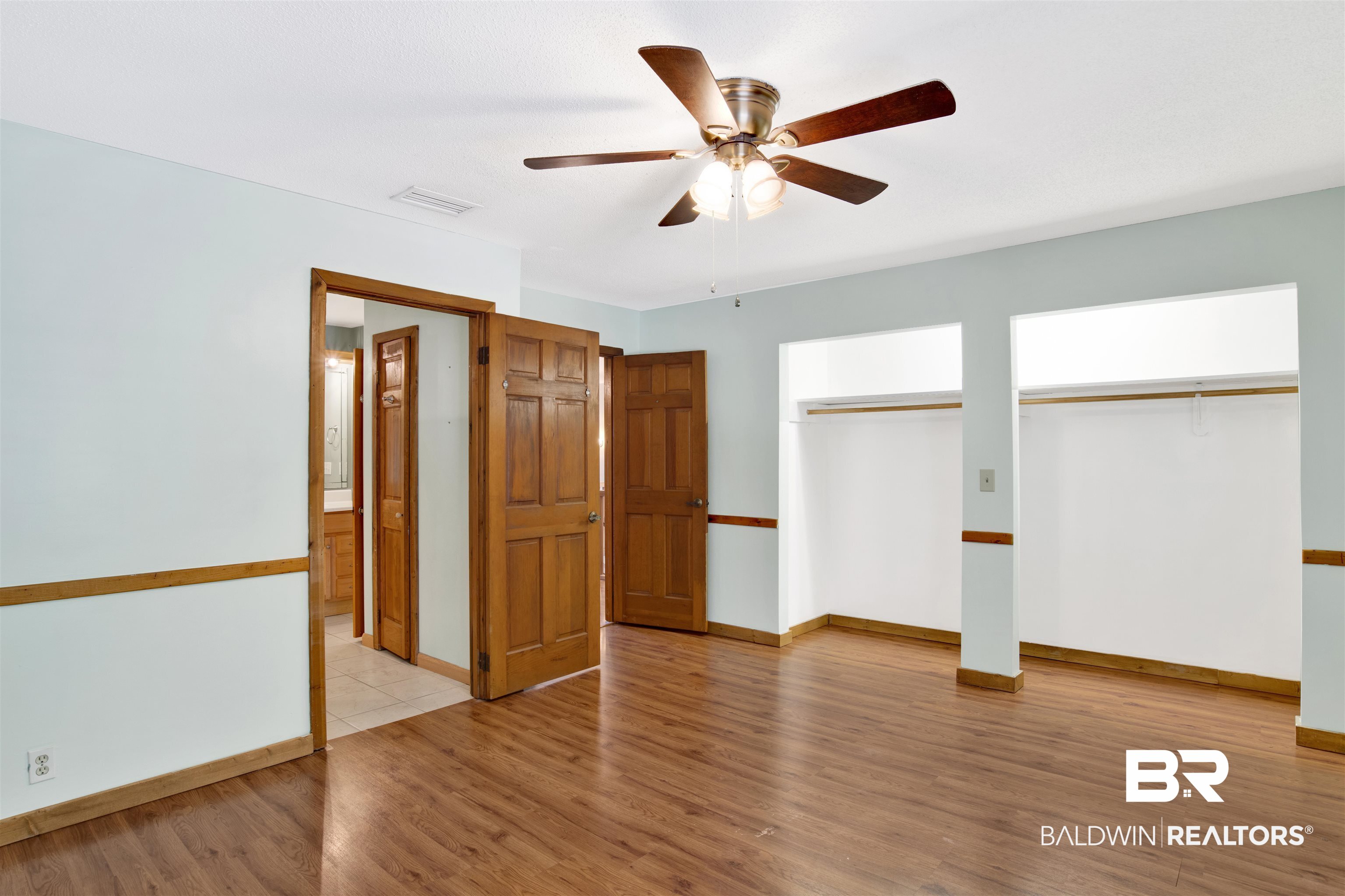 7411 Bay Road Mobile, AL 36605 - Photo 23 of 34 Unfurnished bedroom featuring multiple closets, light wood finished floors, and a ceiling fan