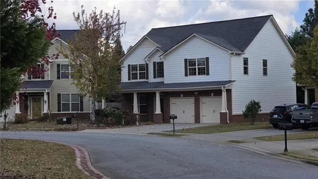 an aerial view of residential house with outdoor space and trees all around
