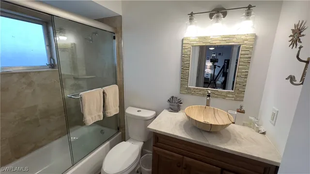 a bathroom with a granite countertop sink toilet a mirror and shower