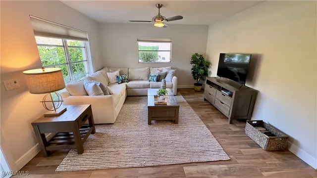 a living room with furniture wooden floor and a flat screen tv