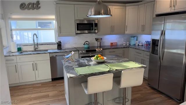a kitchen with a sink a microwave a refrigerator and cabinets