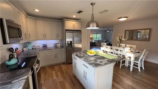 a kitchen that has a lot of cabinets a sink and appliances in it