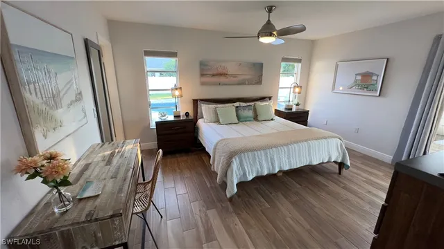 a bedroom with a bed dresser and wooden floor