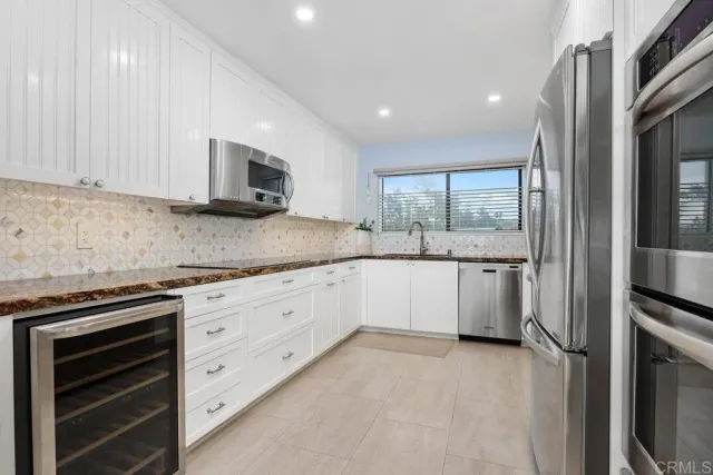 a kitchen with stainless steel appliances white cabinets and a microwave oven
