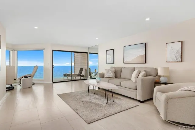 a living room with furniture a flat screen tv and kitchen view