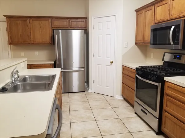 a kitchen with granite countertop a refrigerator and a sink
