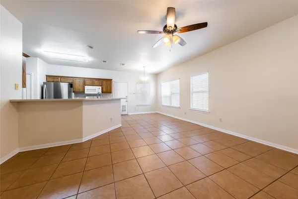 a view of a kitchen and an empty room and window