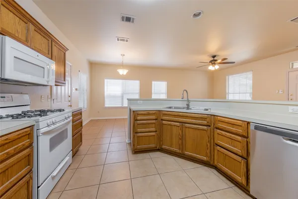 a large kitchen with stainless steel appliances granite countertop a sink and cabinets