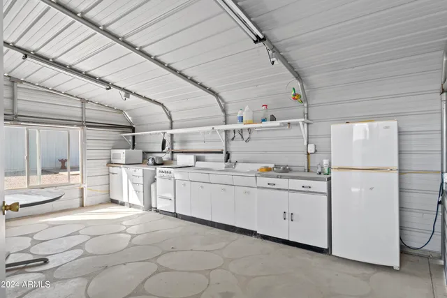 a kitchen with cabinets and chairs