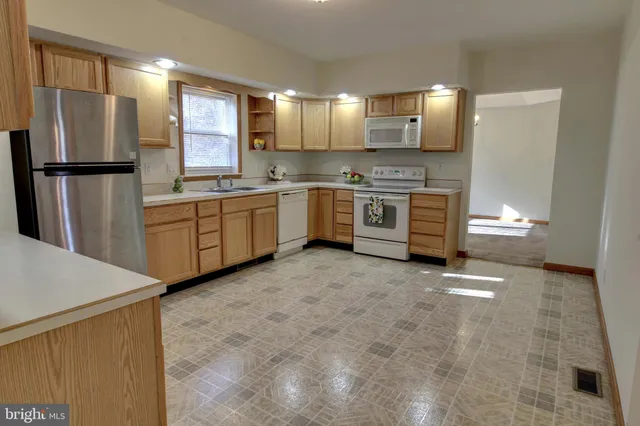a large kitchen with cabinets and refrigerator