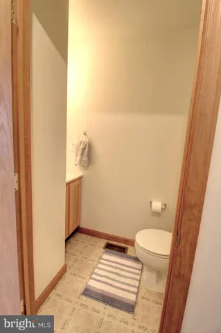 a bathroom with a granite countertop toilet and a sink