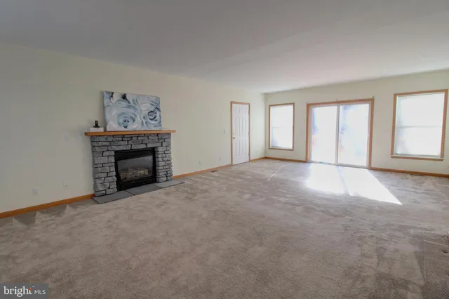 an empty room with fireplace and window