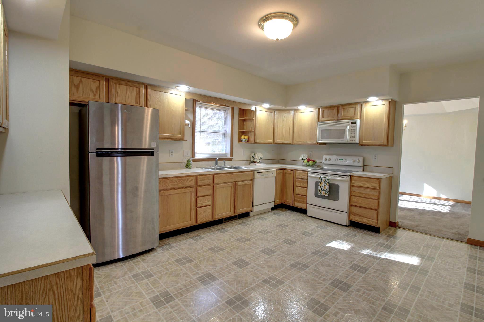745 Fire Trail Road Front Royal, VA 22630 - Photo 8 of 58 a kitchen with stainless steel appliances a refrigerator a sink a stove a microwave a counter space and cabinets