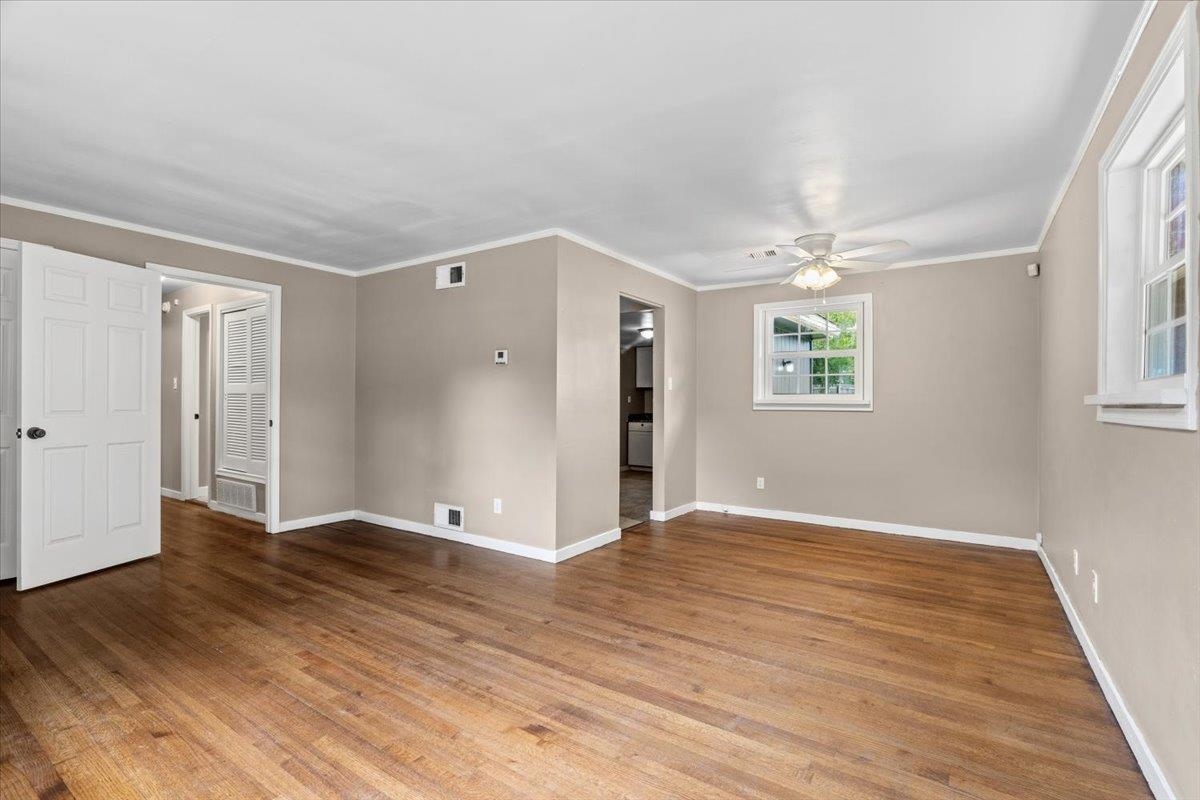 1176 South White Station Road Memphis, TN 38117 - Photo 6 of 15 Spacious room featuring wood-finish flooring, neutral-toned walls, and white trim