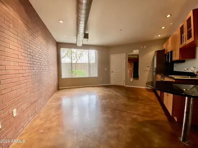 a view of an empty room with a fireplace and a window