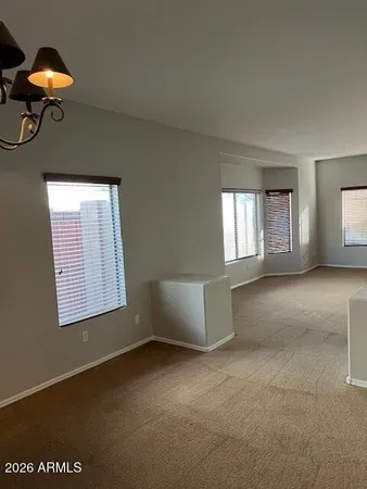 a view of a room with windows and chandelier fan