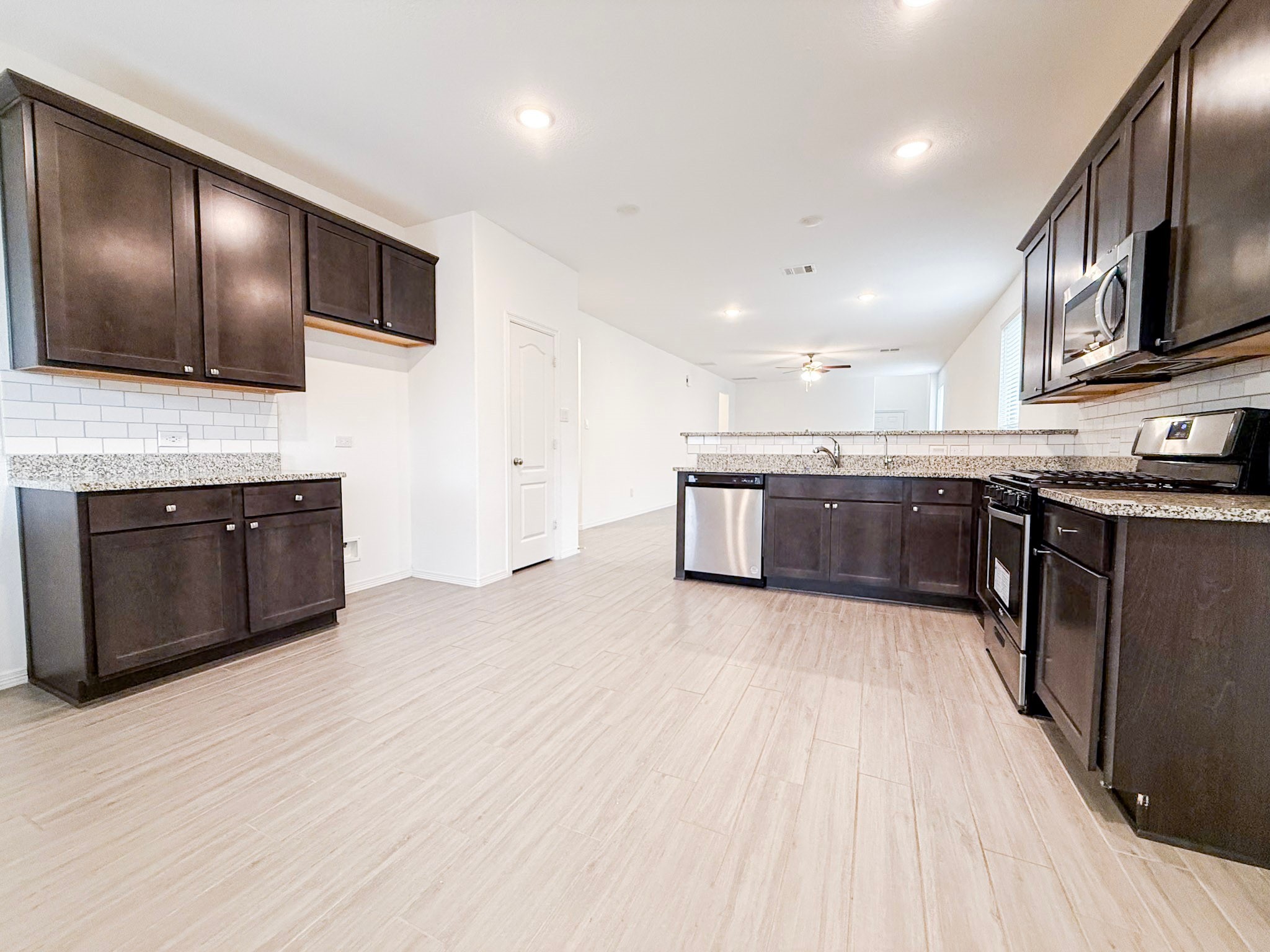 19623 Cat Spruce Court Porter, TX 77365 - Photo 6 of 25 a large kitchen with stainless steel appliances granite countertop a stove refrigerator and microwave