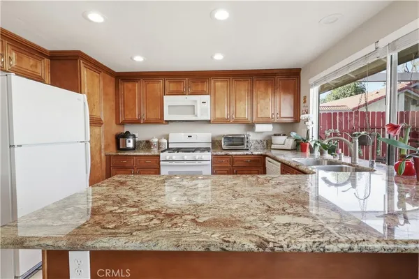 a kitchen with stainless steel appliances granite countertop a refrigerator sink and cabinets