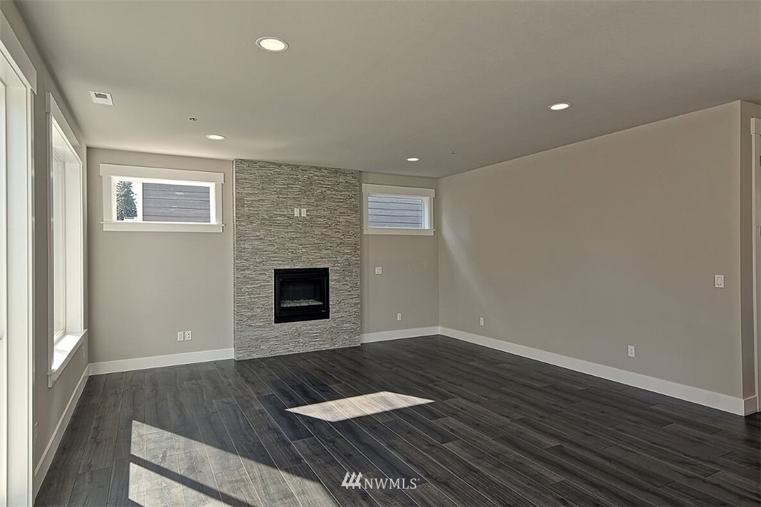 19721 1st Drive Southeast, Unit 8 Bothell, WA 98012 - Photo 14 of 28 an empty room with wooden floor and fireplace