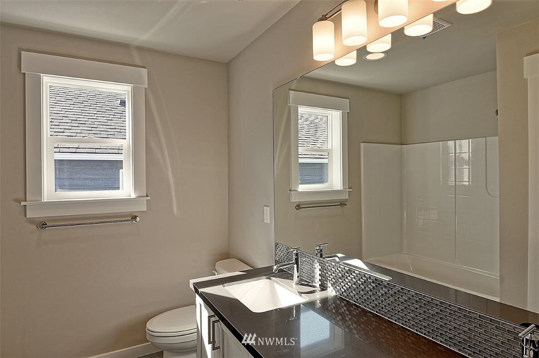 19721 1st Drive Southeast, Unit 8 Bothell, WA 98012 - Photo 25 of 28 a bathroom with a sink a mirror a toilet and a window