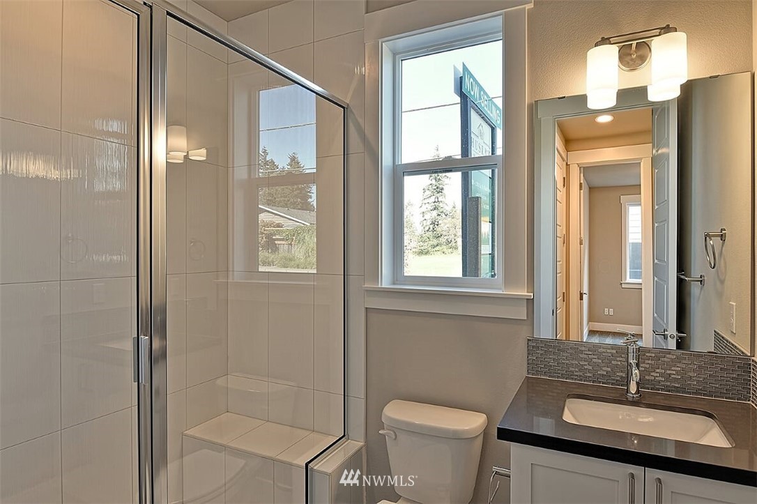 19721 1st Drive Southeast, Unit 8 Bothell, WA 98012 - Photo 6 of 28 a bathroom with a granite countertop sink a toilet and shower